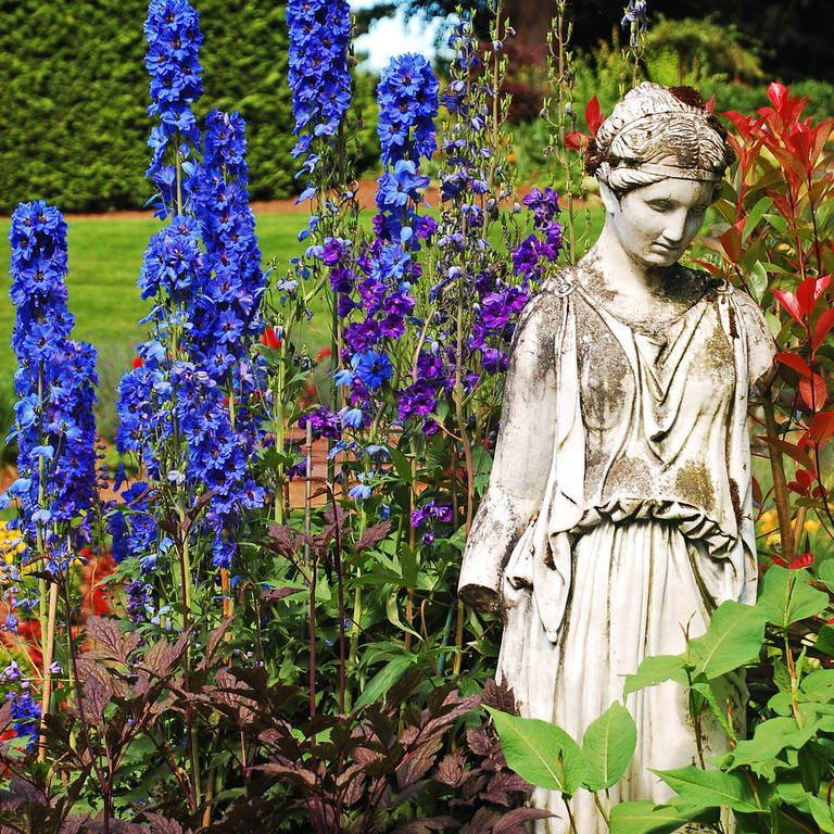 Göttinnenstatue in frühlingshaftem Blumenbeet (Foto: IMAGO, IMAGO / YAY Images)