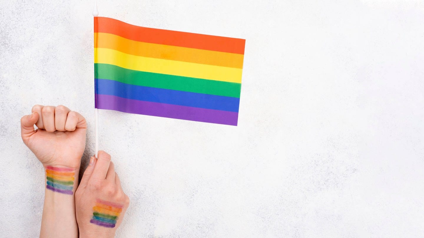 Hand mit Regenbogenflagge (Foto: IMAGO, imageBROKER/OleksandrxLatkun)