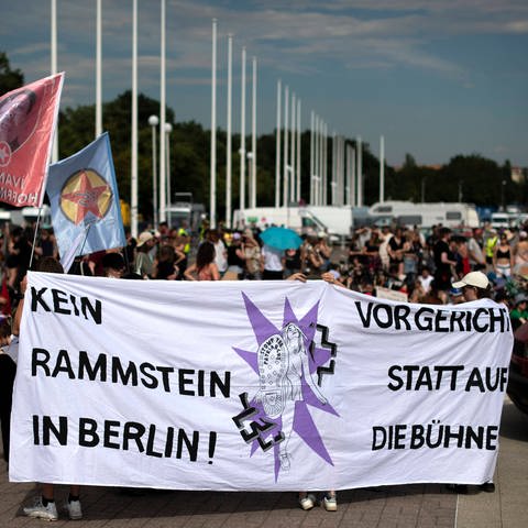 Demonstranten mit einem Transparent „Kein Rammstein in Berlin! Vor Gericht statt auf die Bühne“