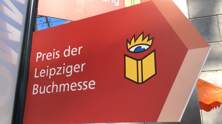 Ein rotes Schild in Pfeilform mit der Aufschrift "Preis der Leipziger Buchmesse" und dem gelben Buchlogo der Buchmesse (Foto: SWR, SWR - Carsten Otte)