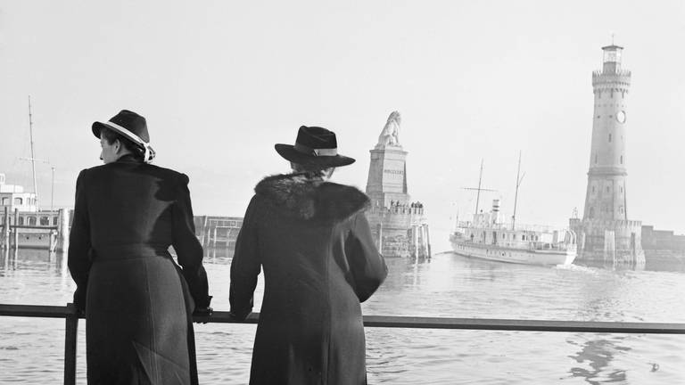 Zwei Frauen blicken auf den Hafen von Lindau am Bodensee