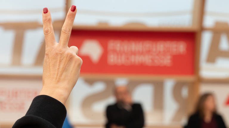 Frankfurter Buchmesse: Eine Frau hebt ihre Finger zum "Victory"-Zeichen (Foto: picture-alliance / Reportdienste, picture alliance/dpa | Sebastian Gollnow)