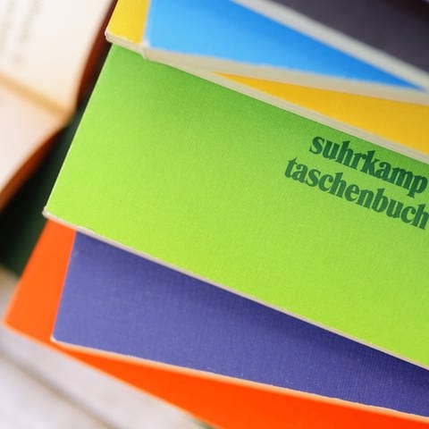 Bücherstapel mit Suhrkamp Taschenbuch (Foto: IMAGO, IMAGO / CHROMORANGE)