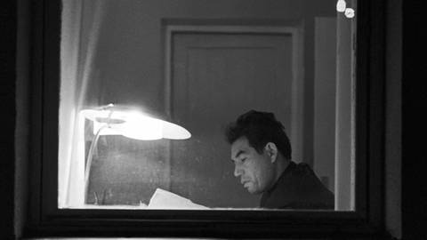 Der Autor Tschingis Aitmatow 1972. Sitzt an einem Fenster und liest an einem Tisch im Schein einer Lampe  (Foto: IMAGO, IMAGO/ITAR-TASS/IMAGO/Oleg Porokhovnikov, A. Kleimenov; )