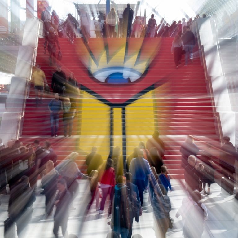 Menschen gehen eine Treppe mit Logo der Leipziger Buchmesse hinauf (Foto: dpa Bildfunk, Picture Alliance)