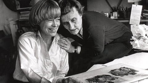 Ilona Wikland und Astrid Lindgren betrachten Illustrationen.
