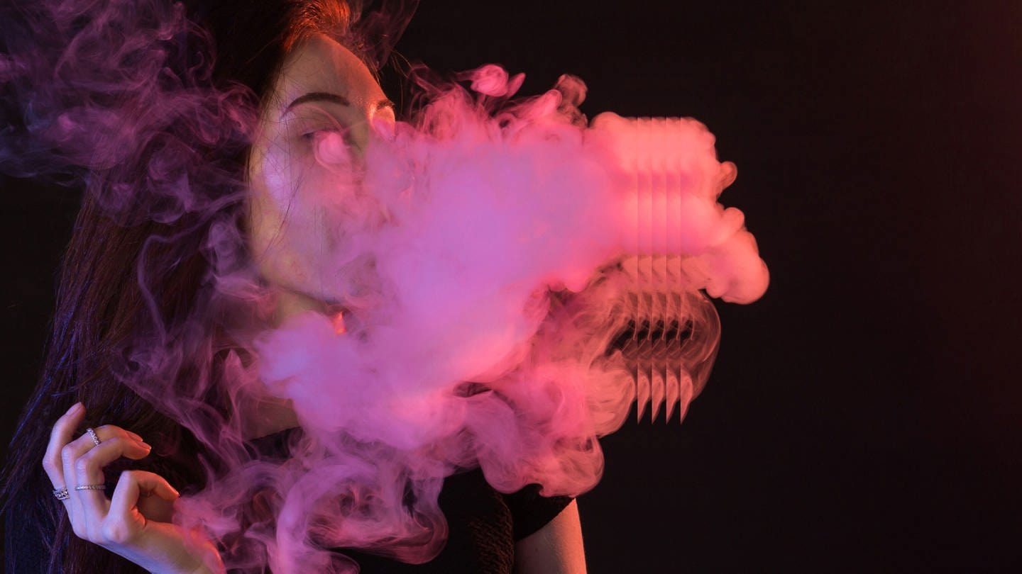 Das Podcastbild von Shit happens. Eine Frau hinter einer Rauchwolke in lila Licht. (Foto: Getty Images, agefotostock)
