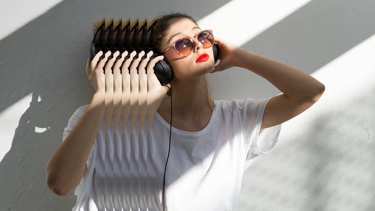 Frau mit Kopfhörern und rotem Lippenstift, mit Echo-Effekt (Foto: IMAGO, imago images / Westend61)
