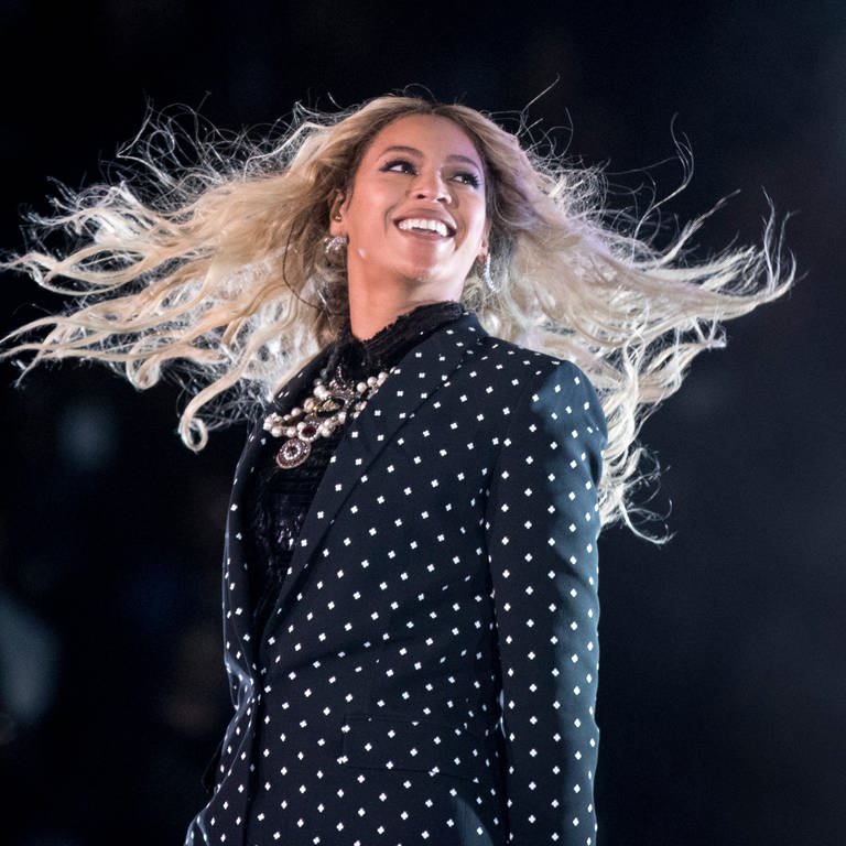 Beyoncés blondierte Haare fliegen bei einer Drehung auf der Bühne