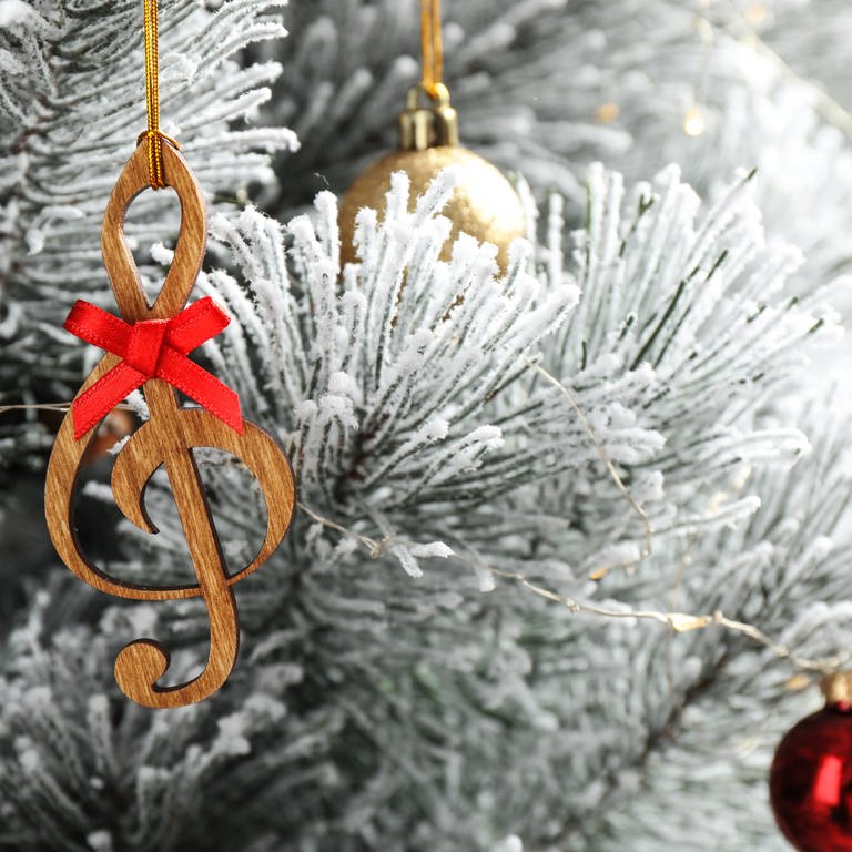 Ein Weihnachtsanhänger der eine Note darstellt hängt an einem weißen Baum  (Foto: IMAGO, IMAGO / Pond5 Images)