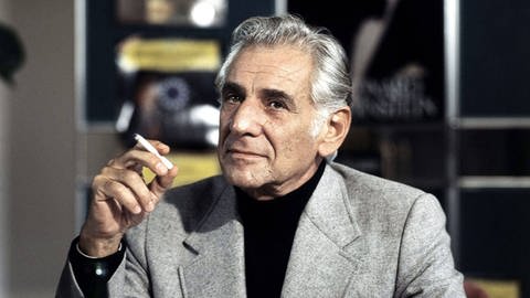 Der Dirigent Leonard Bernstein, eine Zigarette rauchend