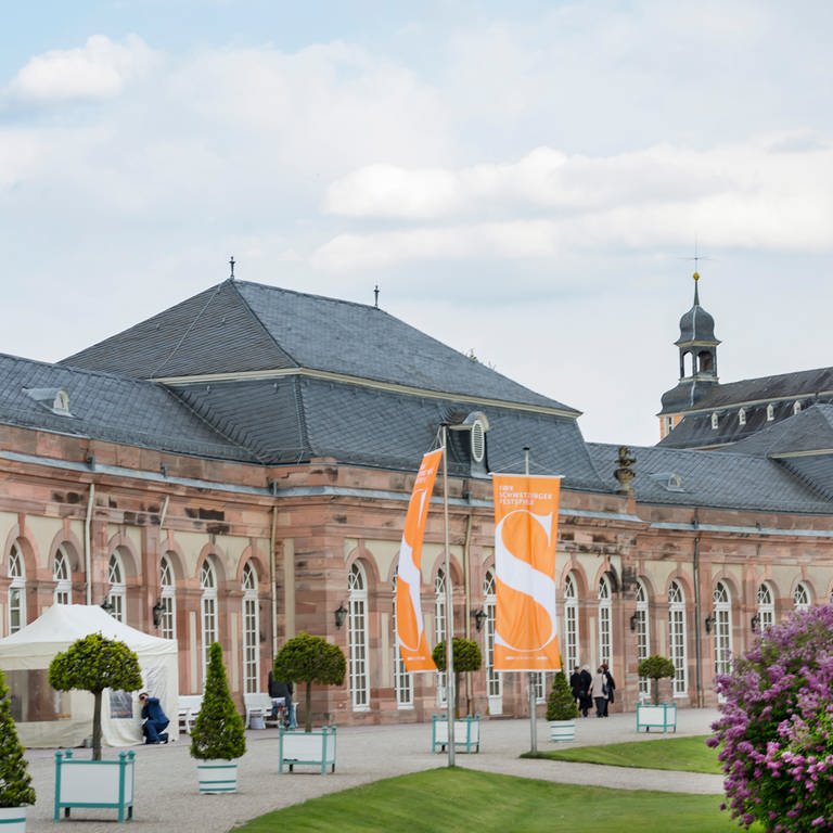 Schwetzinger Schloss mit orangefarbenen Flaggen der Schwetzinger SWR Festspiele davor (Foto: SWR, SWR - Markus Palmer)