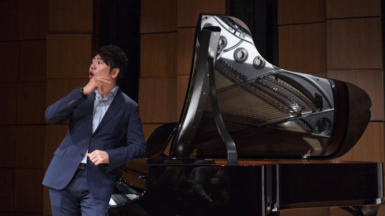 Pianist Lang Lang steht neben seinem Flügel und blickt erstaunt zur Seite (Foto: IMAGO, IMAGO / VCG)