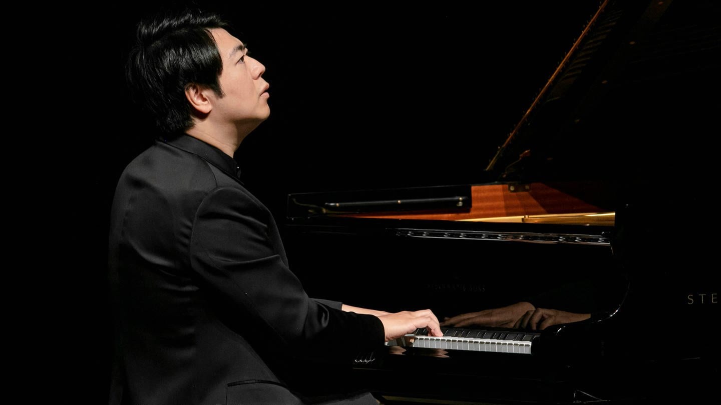 Pianist Lang Lang am Flügel, mit dem Rücken zum Publikum. Er blickt verträumt in die Ferne. (Foto: IMAGO, IMAGO / Andreas Weihs)