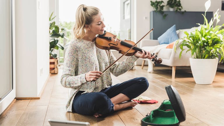 Musik und Freizeit - eine Frau spielt zu Hause Violine