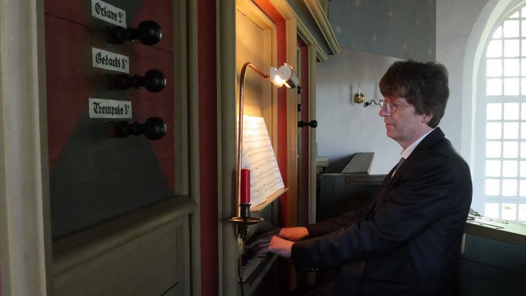 Organist sitzt an der Rysumer Orgel. (Foto: SWR, Thilo Braun)
