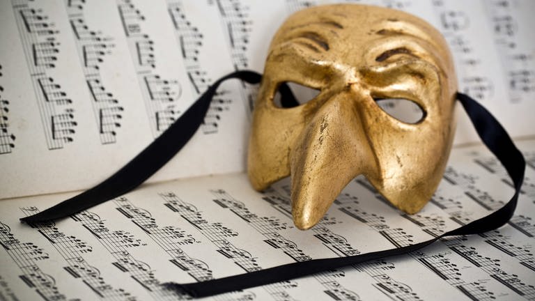 Beautiful carnivale mask from Venice Italy, on a sheet of music  (Foto: IMAGO, IMAGO / agefotostock)
