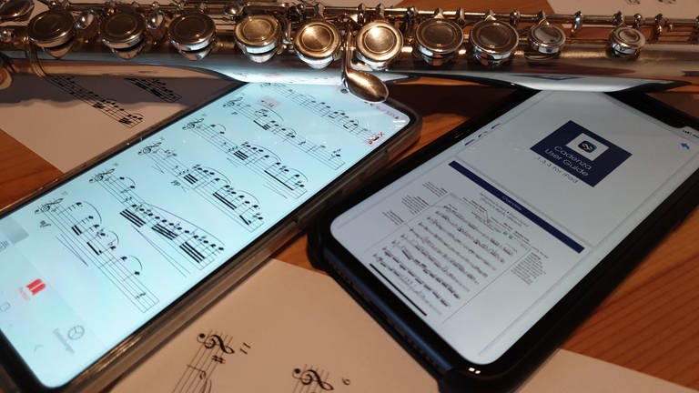 Begleit-Apps für Musiker*innen: Auf einem Tisch liegen zwei Smartphones, eine Querflöte und Notenblätter (Foto: SWR, SWR / Judith Bühler)