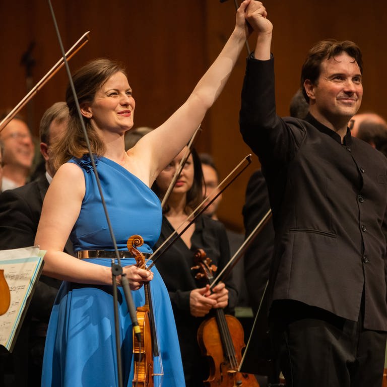Veronika Eberle (Violine) und Alexander Soddy (Dirigent)  beim Schlussapplaus auf der Bühne  (Foto: Pressestelle, © Christian Gaier)