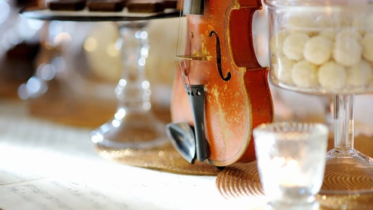 Geige neben Pralinengläsern (Foto: IMAGO, IMAGO / YAY Images)