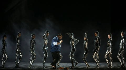 Timothy Fallon neben schwarzen Figuren in der Operette "Die letzte Verschwörung" (Foto: Barbara Pálffy/Volksoper Wien)