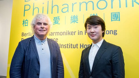 Der koreanische Pianist Seong-Jin Cho und  Sir Simon Rattle im Rahmen einer Pressekonferenz der Berliner Philharmoniker in Hong Kong (2017) (Foto: IMAGO, IMAGO / ZUMA Wire)