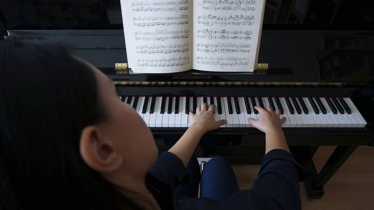 Eine Frau an einem Klavier als Symbolbild für Komponistinnen (Foto: IMAGO, Steinach)