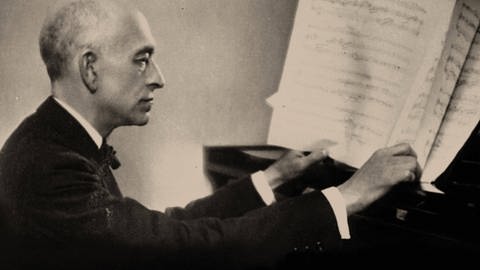 Schwarz-weiß-Aufnahme von Manuel de Falla, am Klavier sitzend und in Noten blätternd (Foto: IMAGO, IMAGO / Heritage Images)