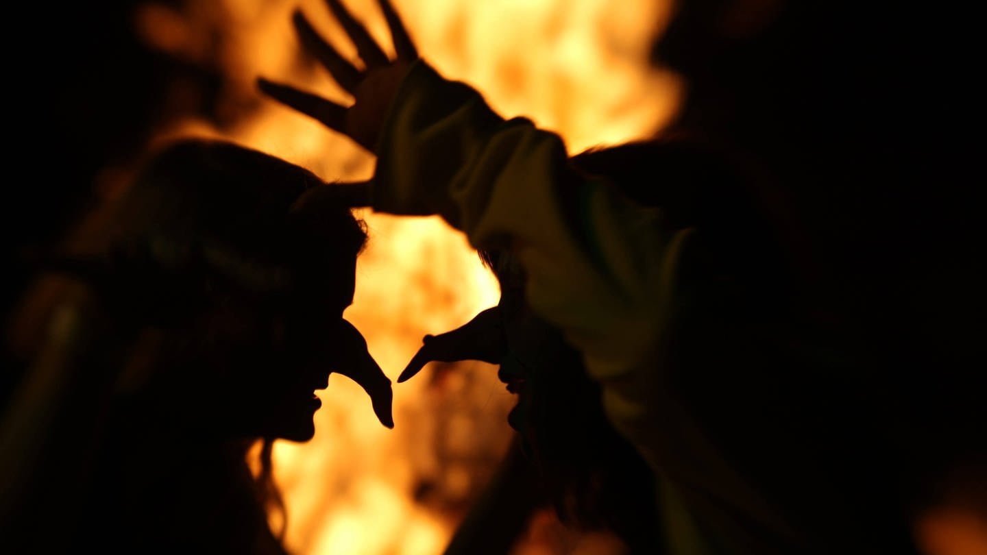 Als Hexen verkleidete Personen tanzen in der Walpurgisnacht vor einem Feuer (Foto: IMAGO, Bild13)