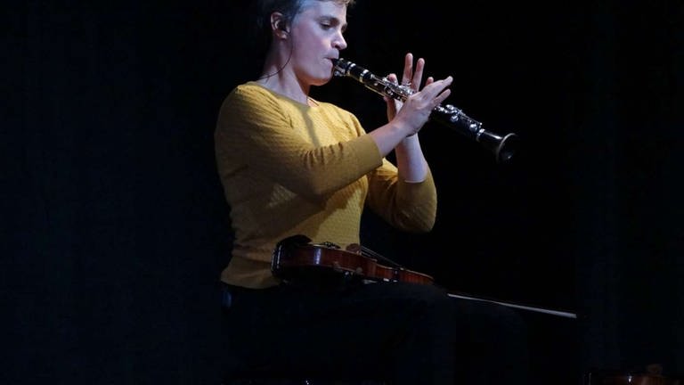 Frau spielt Klarinette mit Geige auf dem Schoß (Foto: SWR, Astrid Karger)
