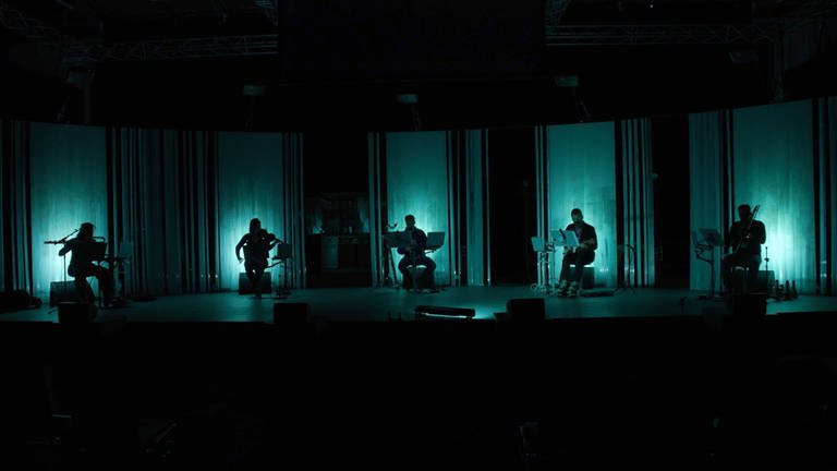 Musiker auf einer schwach beleuchteten Bühne (Foto: SWR, nmzMedia)