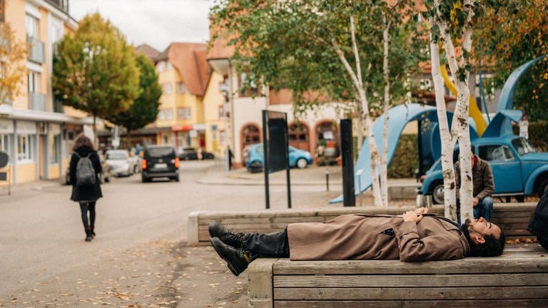 Mann liegt ausgestreckt auf einer Parkbank (Foto: SWR, Oliver Matlok)