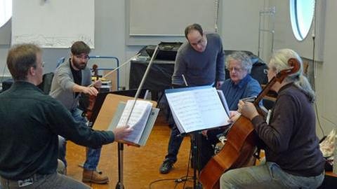Männer von Streichquartett proben mit Komponisten