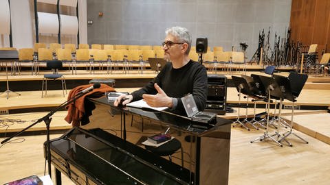 Mann mit schwarzer Brille lehnt an schwarzem Klavier (Foto: SWR)