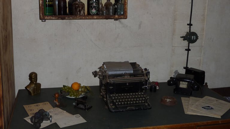 Auf dem Schreibtisch des Kommandanten steht eine kleine Hitler-Büste neben der Schreibmaschine. (Foto: SWR, Claudia Heissenberg)