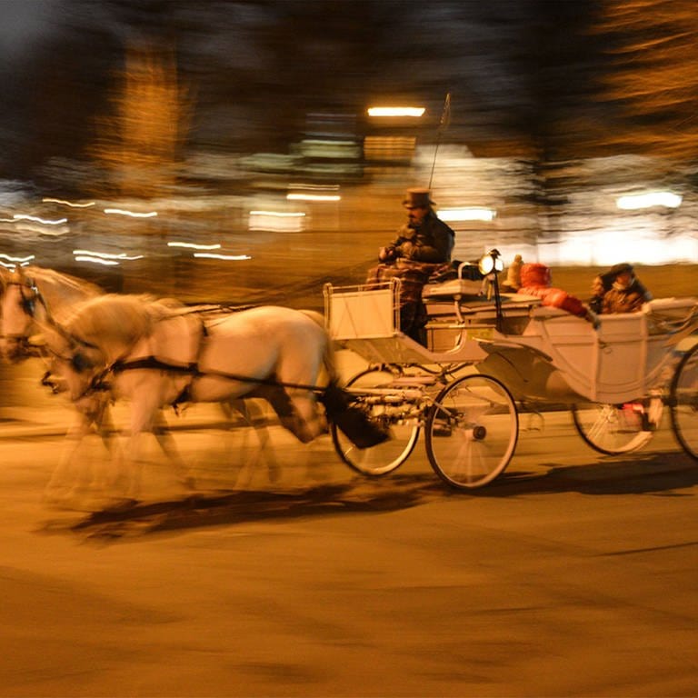 Wiener Fiaker mit Fahrgästen in der Nacht bei schneller Fahrt (Foto: IMAGO, Imago - Rudolf Gigler)