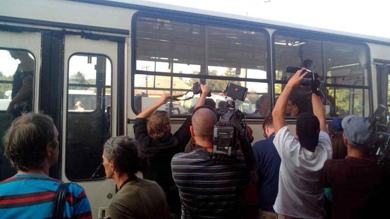 Journalisten belagern einen Bus mit Flüchtlingen (Foto: SWR, SWR - Anna Frenyo)