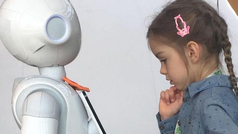 Kind begegnet humanoidem Roboter