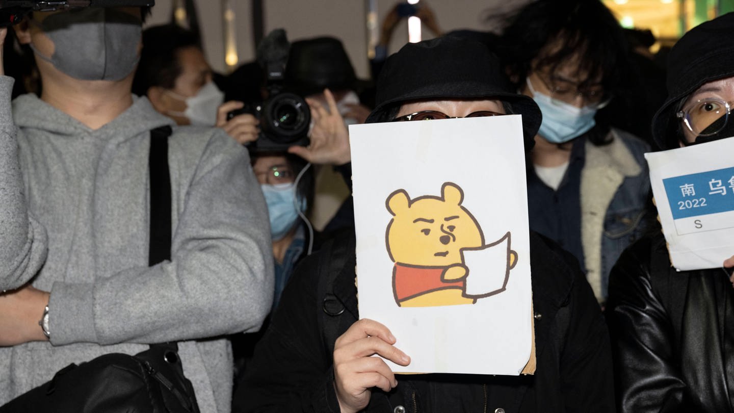 Eine Demonstrierende mit einem Winnie The Pooh Bild gegen die chinesische Obrigkeit (Foto: IMAGO, IMAGO / ZUMA Wire)