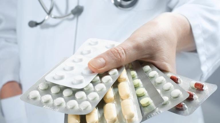 Ein Arzt hält mehrere Tablettenpackungen in der Hand. (Foto: Getty Images, Thinkstock -)