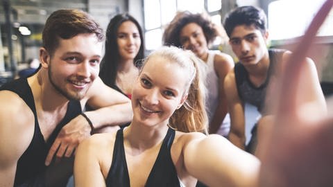 Jugendliche posen im Fitnessstudio für ein Selfie. Problematisch: Jungs greifen für den Muskelaufbau auch zu anabolen Steroiden