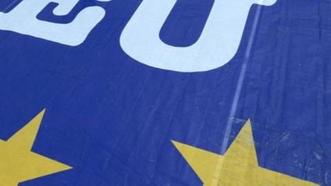 Ein Mann geht am 21.05.2014 in Wiesbaden (Hessen) über ein Aktionsbanner mit der Aufschrift "I vote EU" (Foto: picture-alliance / dpa, picture-alliance / dpa - Arne Dedert)