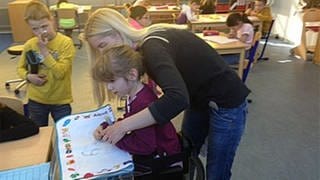 Eine Lehrerin hilft einer Schülerin in der Körperbehindertenschule in Kronau (Foto: SWR, SWR -)