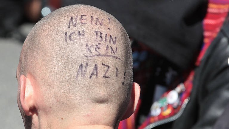 Glatze eines Mannes mit der Aufschrift: Nein! Ich bin kein Nazi! (Foto: IMAGO, imago images / Steffen Schellhorn)