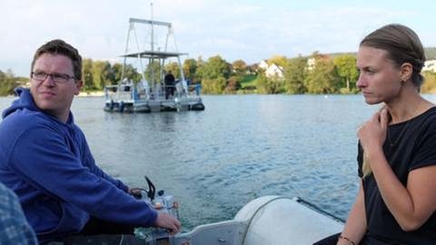 Zwei Klimaforscher sind mit einem Schlauchboot unterwegs zu einer Mini-Bohrinsel im Stahringer See. Dort entnehmen sie Proben aus dem Seeboden. (Foto: SWR, SWR - Max Rauner)