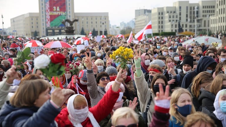 Demonstrantinnen halten während einer Kundgebung der Opposition am 26. Oktober 2020 in Minsk Blumen und protestieren gegen die offiziellen Ergebnisse der Präsidentschaftswahlen in Belarus (Foto: picture-alliance / Reportdienste, picture alliance / ASSOCIATED PRESS | Uncredited)