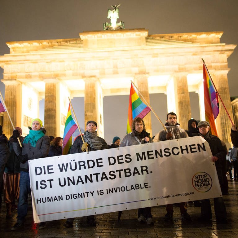 "Die Würde des Menschen ist unverletztlich" steht auf dem Transparent bei einer Demonstration vor dem Brandenburger Tor (Foto: IMAGO, IMAGO / Christian Mang)