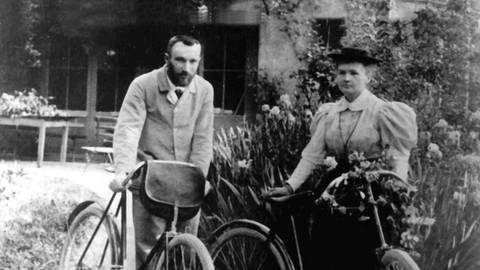 Die polnisch-französische Wissenschaftlerin Marie Curie mit ihrem Mann Pierre einige Monate nach ihrer Hochzeit im Jahr 1896 – mit Fahrraädern