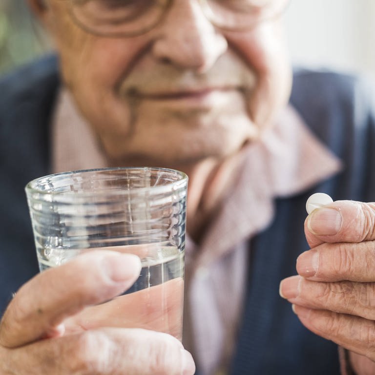 Ein Senior nimmt eine Tablette (Foto: IMAGO, imago images / Westend61)