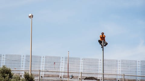 Ein Asylsuchender auf dem Grenzzaun der spanischen Enklave Melilla an der nordafrikanischen Mittelmeerküste. 2014 wurden dort zwei Asylsuchende durch ein Pushback zurückgedrängt. Daraufhin entschied der Europäische Gerichtshof für Menschenrechte, dass Pushbacks unter gewissen Umständen erlaubt sein können.